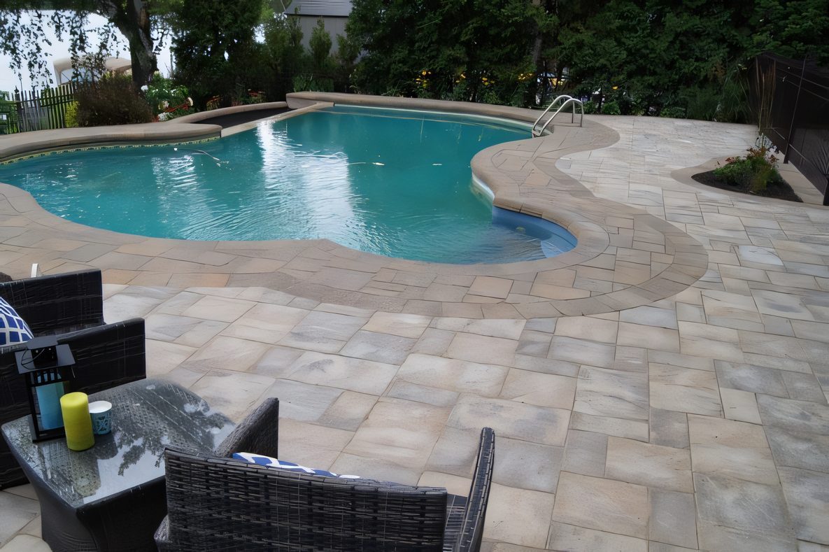 Piscine au bord du lac, chaises de rotin sur le pavé