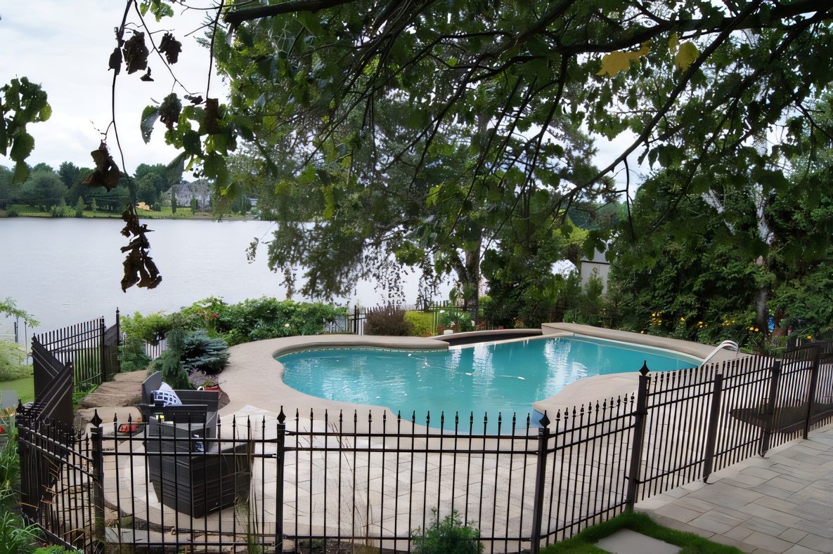 La piscine vue à travers les arbres, terrasse de pavé