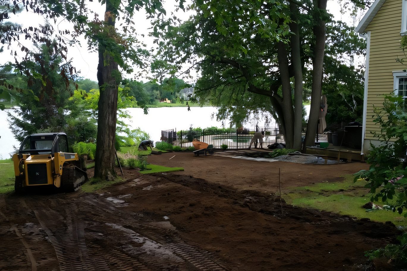 Le chantier de la piscine au bord du lac : terre remuée, pelle chenillée